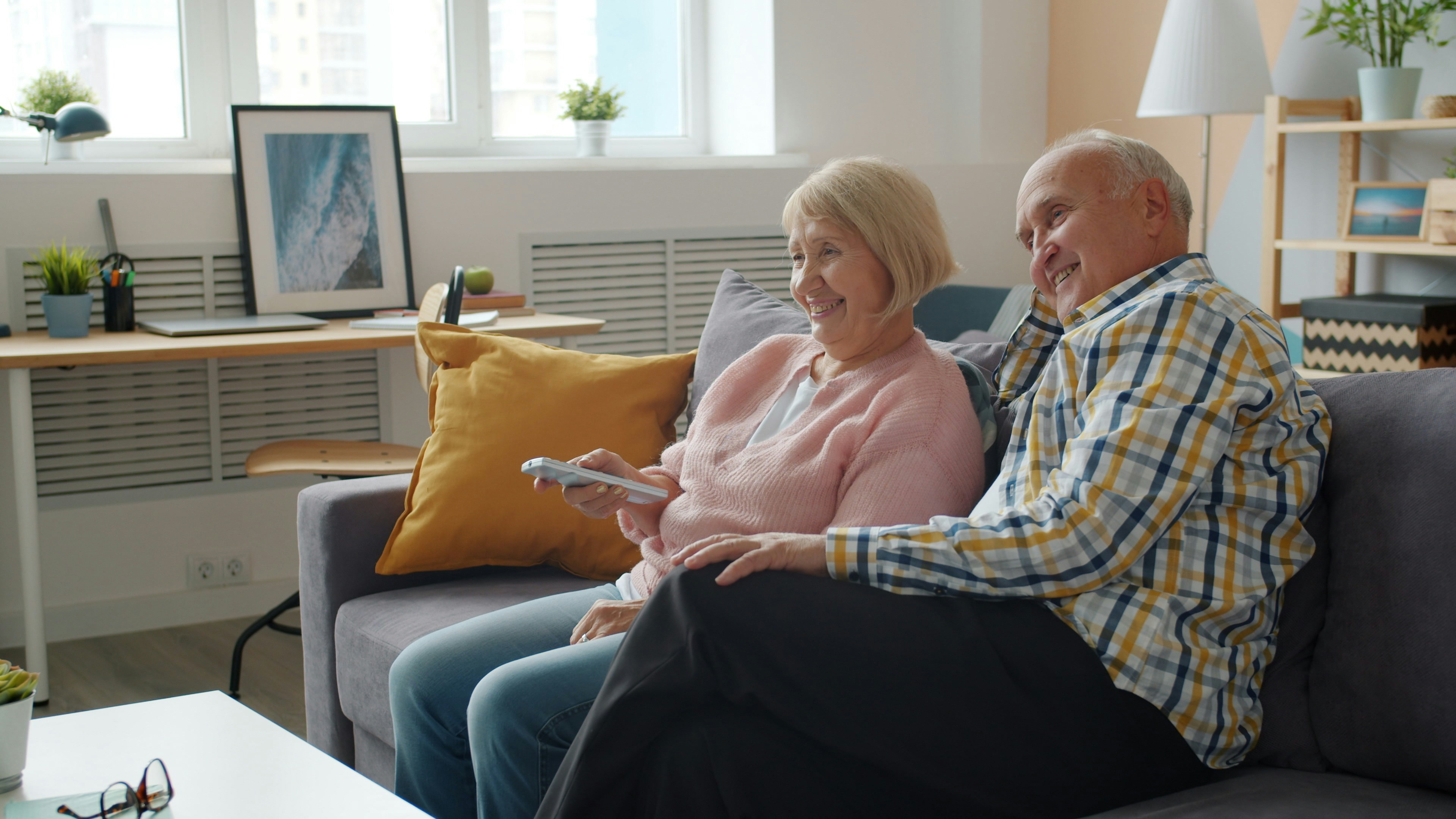 Elderly couple relaxing comfortably together at home on the sofa